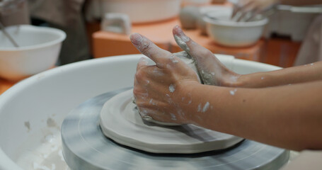 Hand work on pottery wheel, shaping a clay pot