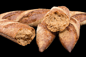 Freshly baked homemade bread isolated on black. French bread baguette. Healthy eating and traditional bakery, baking bread concept