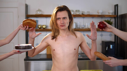 Portrait of shirtless thin man refusing to eat food being on severe diet