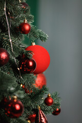 Red balls decorate a Christmas tree. Selective focus.