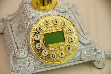 Antique telephone with a wire. Gold numbers