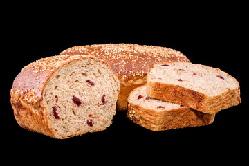Freshly baked homemade bread isolated on black. Cut in half rye bread with red berries. Healthy eating and traditional bakery, baking bread concept