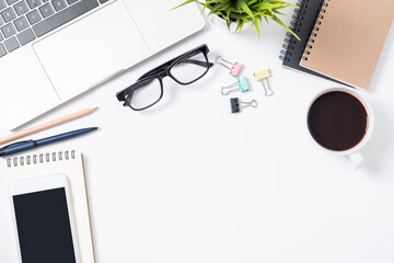 Flat lay of White office desk table or workplace with laptop, and smartphone and coffee cup with equipment other office supplies with copy space, top view