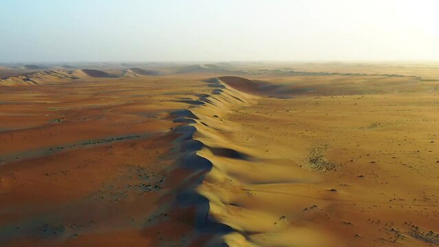 Aerial view of a line of sand dunes, in middle of desert, - tilt up, drone shot