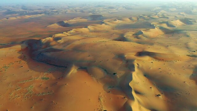 Aerial view of sand dunes, in middle of desert sunset, - descending, drone shot