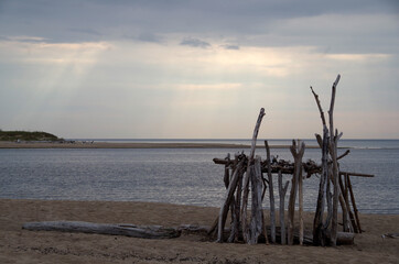 Mysterious construction of sticks on the seashore in cloudy weather