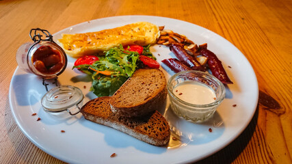 A delicious and delicious breakfast of fried eggs, sausages, champignons as well as lettuce and tomatoes