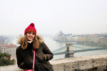 Fototapeta na wymiar young girl smiling in front of budapest cityscape in winter