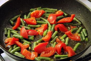 Tomato and green beans roasted on the black frying pan for morning roasted whole eggs