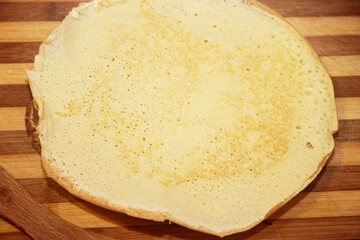 Stack of homemade pancakes on wood cooking board