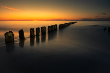Wooden breakwater at the sunset over Baltic Sea