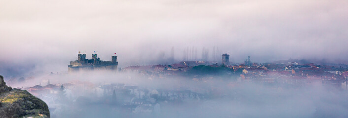 pueblo en l niebla con castillo 