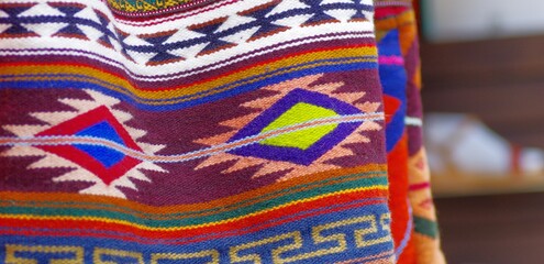 Colorful market with beautiful and unique handicraft fabric patterns available in Otavalo, Ecuador