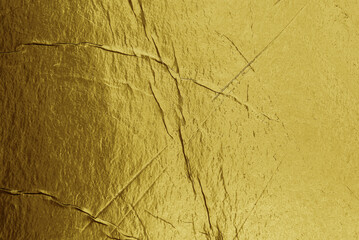 Grunge gold foil texture background with cracks and scratches