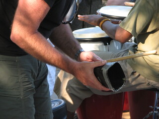 musicians playing cowbell and hand drum in drum circle 