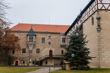 Fortified medieval stronghold, Moated gothic castle at romantic style, National cultural landmark with Christmas tree in winter day, Budyne nad Ohri, Bohemia, Czech Republic