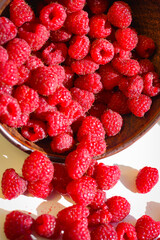 Red ripe and juicy raspberry in an inverted small bowl