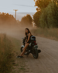 Young woman leaning on a motorcycle on dirt road next to golden grass,
Fashion Campaign, Tourist Advertising, Travel, Nature, Mechanic, Motorbike, Woman