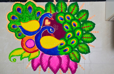 designer colorful peacock rangoli design on tile during diwali