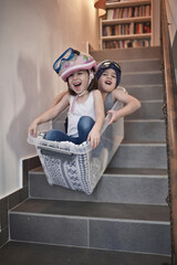 Kids sledding down stairs in a storage box