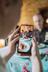 Close-up of a woman's hands while using an application on her smathphone - A woman's hand taking a picture of her plate of food and her man.