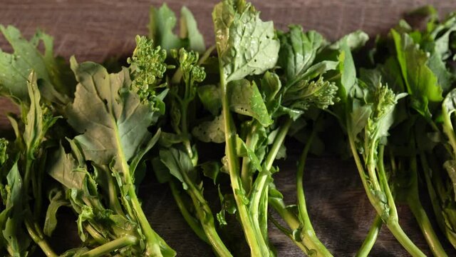 Slider to the right of beautifully lit extreme closeup of broccoli rabe, rapini.