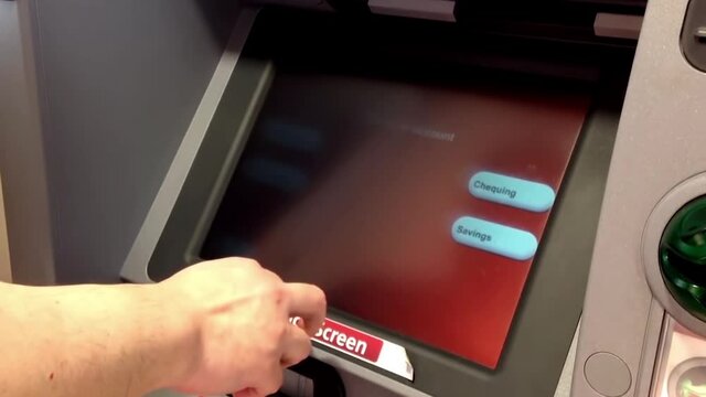 Man depositing cheque at ATM machine inside Cibc bank