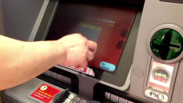 Man depositing cheque at ATM machine inside Cibc bank