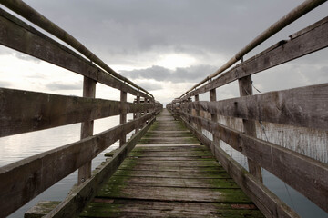 Old wooden pier, in a cloudy day, Trasimeno Lake, naturalistic oasis of  "La valle",  San Savino, municipality of Magione,  Umbria, Italy