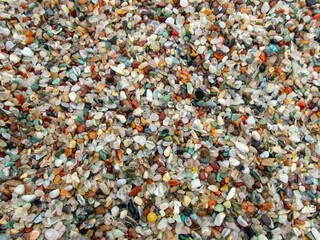 A pile full of small agate stones makes a pretty colorful background or backdrop with lots of color, shapes and sizes. Slight bokeh effect.
