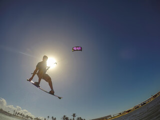 SILHOUETTE: Male tourist having fun kiteboarding during his vacation in Brazil