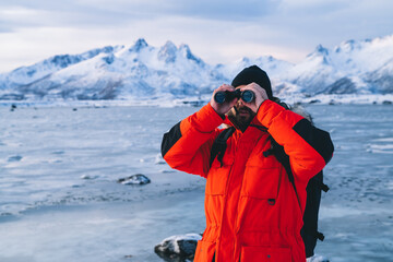 Fototapeta na wymiar Explorer with binoculars on froze shoreline