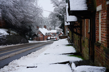 Empty snow covered road through a quiet village