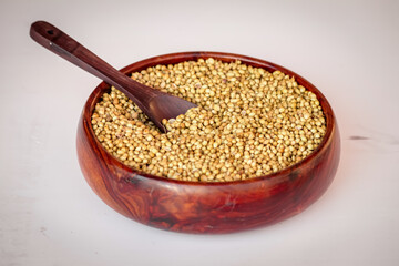 Coriander seeds in a big wooden bowl, coriander seeds and wooden spoon beautiful footage,raw Organic coriander Seeds in a Bowl,selective focus on subject,dried coriander seed bowl