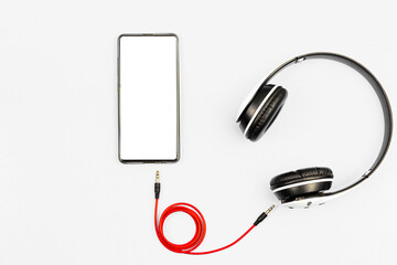 Headphones and smartphone on white background