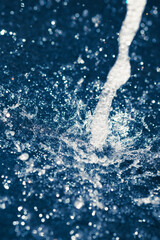 water stream with splash drops, blue background