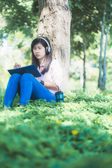 Woman sitting in the park listening to music