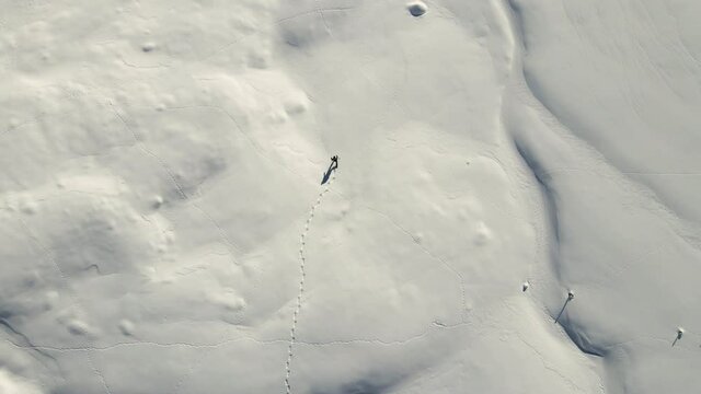 A single Man is hiking in the middle of the snowy italian mountains with his snow shoes. (ciaspole)