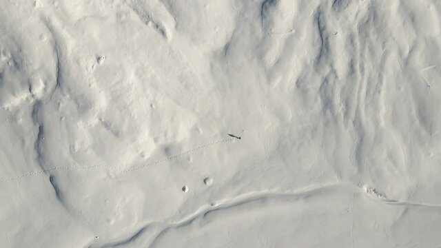 A single Man is hiking in the middle of the snowy italian mountains with his snow shoes. (ciaspole)