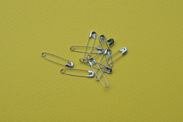 Fototapeta premium a bunch of many gray metal pins lie on a yellow table