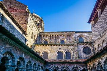 Fototapeta premium The 12th century cloister of Notre Dame cathedral in le Puy en Velay (Auvergne, France) is a medieval wonder with its amazing romanesque and colorful architecture