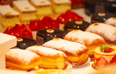 Assortment of french fresh baked sweet pastry with fresh fruits and berries in confectionery shop