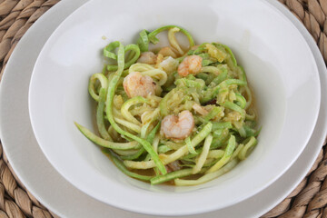 fresh and raw zucchini spaguetti with prawns as imitation of italian pasta for vegetarian food