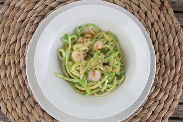 fresh and raw zucchini spaguetti with prawns as imitation of italian pasta for vegetarian food