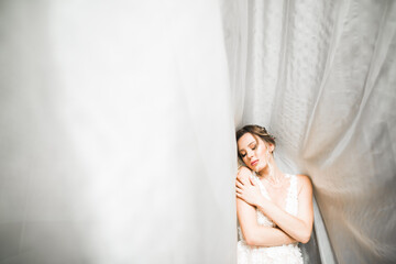 Portrait of beautiful bride with fashion veil at wedding morning