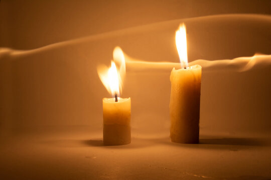 Photo of a burning candle with a yellow flame	