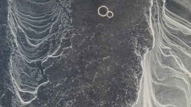 three people ice skating on a frozen lake that has a pattern that looks like from another planet