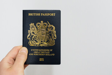 Hand holding a British passport.