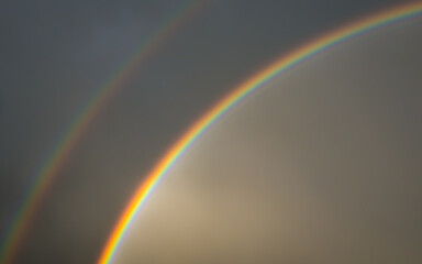 Double rainbow in dark sky after rain