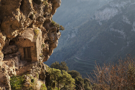 glimpse of a stone cabin embedded in a rock wall along the Path of God ( Il sentiero degli dei)  mediterranean landscape, Campania, Southern Italy, Europe.